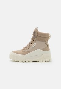 Beige veterschoenen tot de enkel met een bovenwerk van suède, rubberen zool, textuuraccenten en opvallende profieldetails, met een gevoerde kraag.