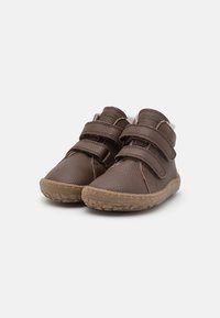 Chaussures pour enfants en cuir marron avec deux sangles velcro ajustables. Surface texturée et semelles en caoutchouc avec un motif de semelle pour une meilleure adhérence.