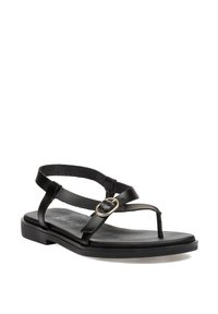 Sandalia de cuero negro con suela plana, con tiras delgadas y un acento de hebilla redonda. Textura suave y diseño minimalista.