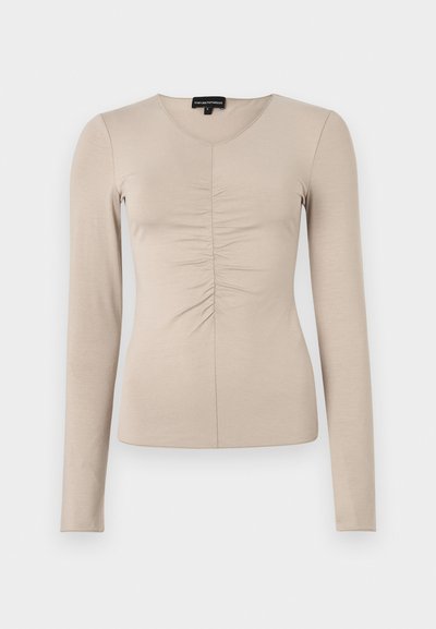 Hosszú ujjú, v-nyakú felső világos bézs anyagból. Az elülső középső részen ráncolt részletekkel. Puha, sima textúrájú.