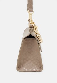 Borsa trapezoidale taupe con lato texturizzato, dettaglio in catena dorata e tracolla taupe coordinata su sfondo bianco.