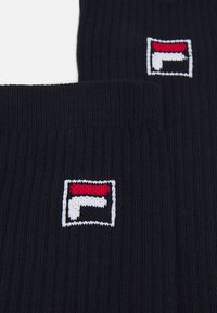 Jūras spēku tumši zili ribotu zeķu pāris ar nelielu baltu, sarkanu un melnu logo birku. Izgatavotas no mīkstas auduma, ar strukturētu virsmu.