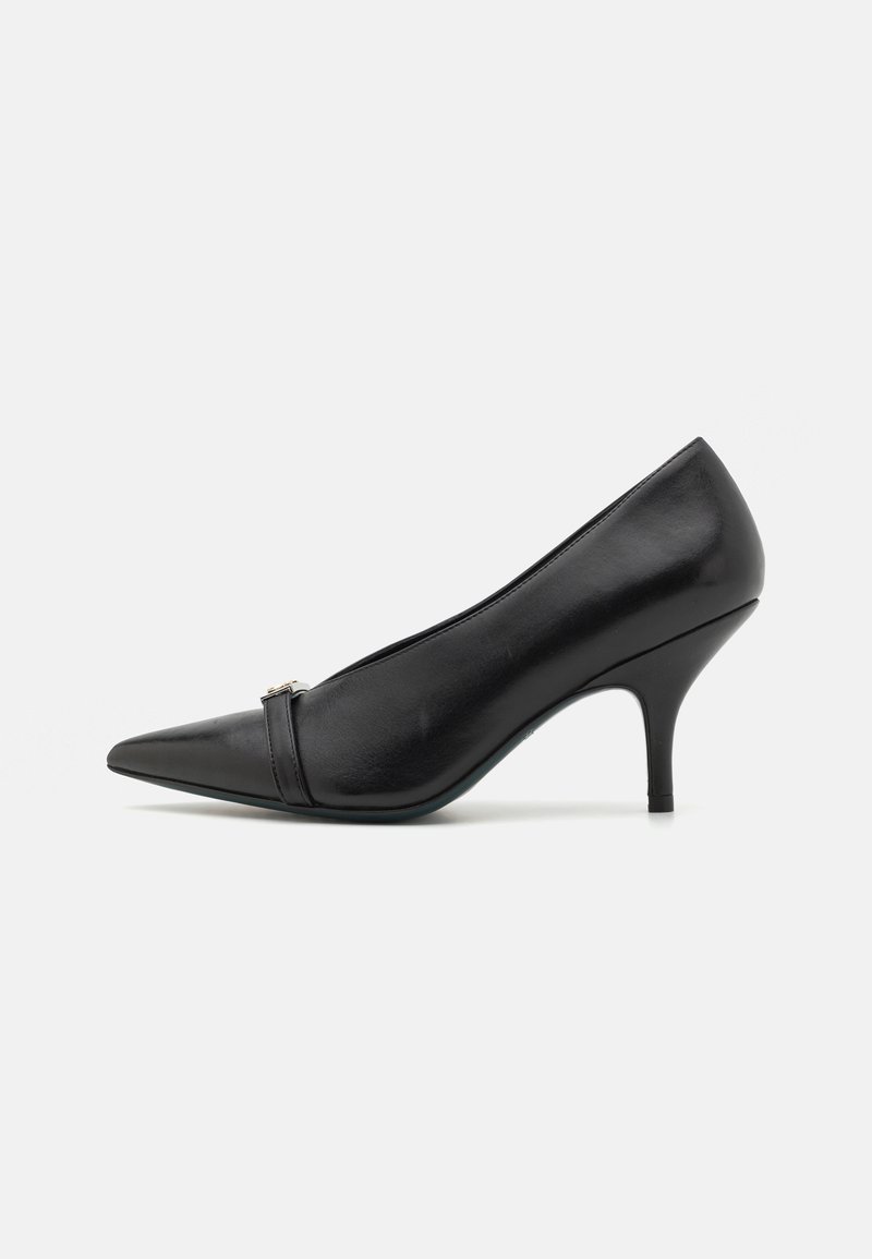 Black leather high-heeled shoe with a pointed toe and curved silhouette, featuring a decorative strap across the upper and a thin heel.