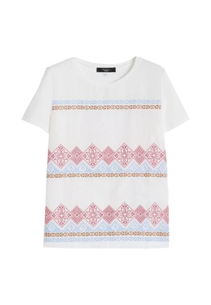 Camicia bianca a maniche corte con motivi a rombi rossi e fiocchi di neve, zigzag blu e strisce decorative orizzontali marroni sul davanti.