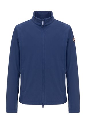 Merensininen kevyt takki, jossa täysipitkä vetoketju edessä, pystypystykaulus, sivutaskut ja pieni pyöreä logo vasemmassa hihassa.