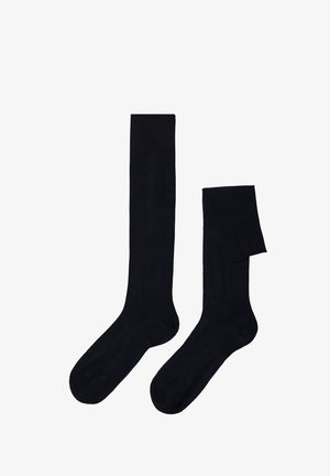 Skarpetki do kolan w jednolitym czarnym kolorze, wykonane z gładkiego, elastycznego materiału. Posiadają gruby, prążkowany pas u góry oraz bezszwową konstrukcję palców.