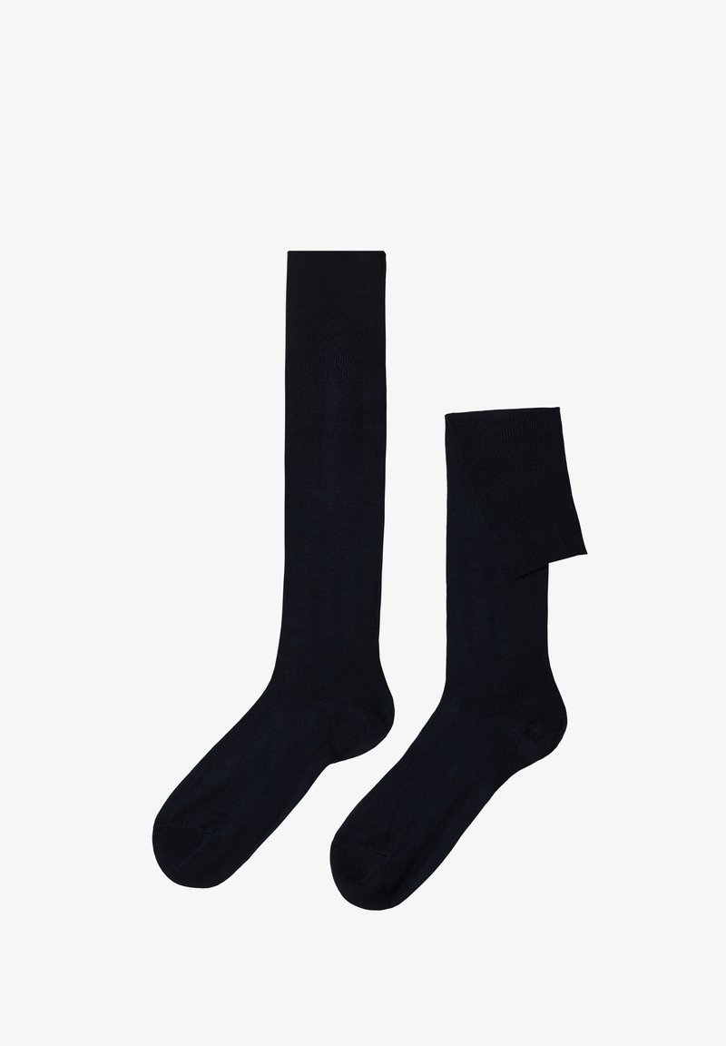 Skarpetki do kolan w jednolitym czarnym kolorze, wykonane z gładkiego, elastycznego materiału. Posiadają gruby, prążkowany pas u góry oraz bezszwową konstrukcję palców.