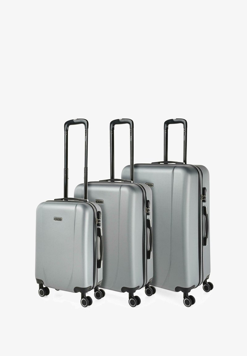 Tres maletas rígidas plateadas en tamaños pequeño, mediano y grande, con asas telescópicas negras extendidas y cuatro ruedas negras cada una.