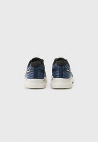 Blaue und schwarze Sportschuhe mit einem strukturierten Mesh-Obermaterial, weißer Zwischensohle und grünen Akzenten an der Außensohle. Die Rückansicht zeigt ein verstärktes Fersen-Design.