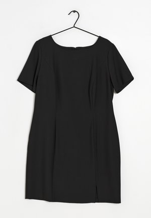 Černé šaty s krátkými rukávy a délkou ke kolenům, kulatým výstřihem, zavěšené na černém kovovém ramínku na bílém pozadí.