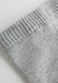 Gray knitted fabric showing a ribbed cuff section. The texture is soft with a medium gauge, featuring a heathered pattern of light and dark fibers.