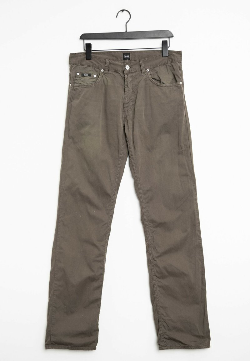 Pantalones de algodón verde oliva, diseño de pierna recta, con dos bolsillos delanteros, cierre de botón y costuras en contraste. Suspendidos de una percha negra.