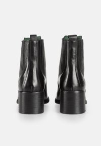 Stivali alla caviglia in pelle nera con design a coste, fodera interna verde e tacco impilato. Presentano dettagli di cucitura e logo impresso sul tacco.