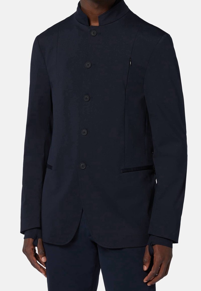 Marinblå blazer med ståkrage, sex knappar och sidofickor. Tillverkad av slät tyg med skräddarsydd passform och subtil lyster.