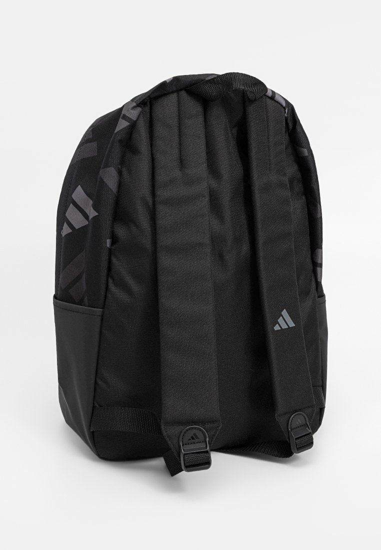Sac à dos noir avec des bretelles rembourrées, des boucles réglables, des poches latérales et un logo subtil d'Adidas sur la sangle, sur fond blanc.