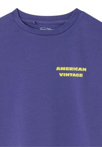 T-shirt violet à col rond avec l'inscription "AMERICAN VINTAGE" en jaune sur le haut gauche de la poitrine.