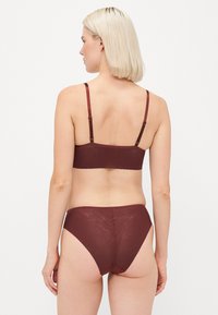 Top de soutien (bralette) marrom e cuecas de cintura alta em tecido texturizado, com padrões subtis e alças ajustáveis para um ajuste seguro.