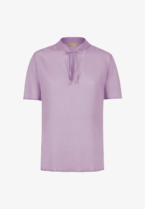 Jasnofioletowa bluzka z krótkim rękawem, pionowymi paskami, okrągłym kołnierzykiem i dekoltem w kształcie klucza zawiązana małą kokardką.