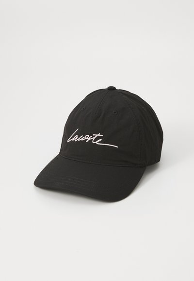 Casquette de baseball noire en tissu avec une visière incurvée. Équipée d'un logo "Lacoste" brodé en blanc à l'avant. Sangle ajustable à l'arrière.