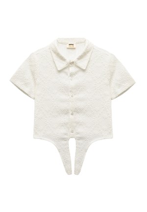 Weiße kurzärmelige Bluse mit einem strukturierten Rautenmuster. Verfügt über einen spitzen Kragen und Knopfverschlüsse sowie ein einzigartiges Split-Hem-Design.