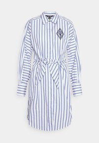 Randig skjortklänning i vitt och blått, med krage, långa ärmar, knytning i midjan och en broderad logotyp på bröstet. Tillverkad av bomull.