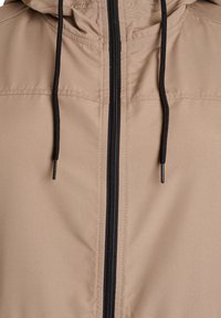 Beige Kapuzenjacke mit schwarzem Reißverschluss, ausgestattet mit verstellbarem Kordelzug, glatter Textur und abgesteppten Details auf der Vorderseite.