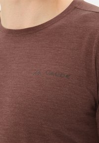Bordeaux korte mouwen T-shirt van een gestructureerde stof, met een subtiele reliëflogo op de voorkant en een ronde halslijn.