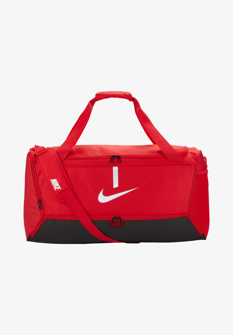 Saco de duffel vermelho com acabamentos pretos, feito de um tecido durável. Apresenta duas alças superiores, uma alça de ombro ajustável e um logótipo branco da Nike.