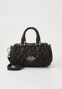 Svart handväska i quiltat konstläder, med en guldfärgad logotypplakett, dubbla övre handtag och en avtagbar axelrem.