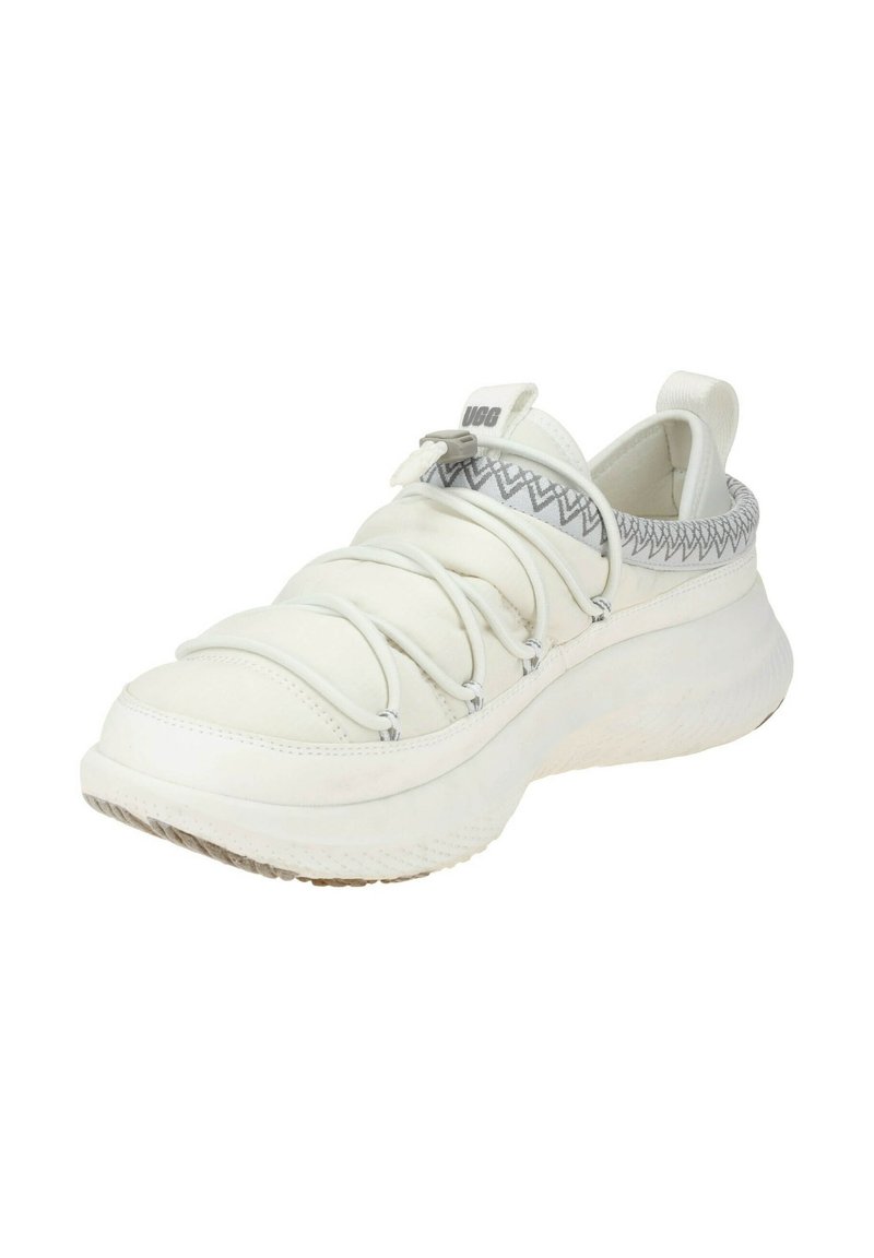 Witte sneaker met elastische bovenkant, textuur op de kraag en lichtgrijs zigzagpatroon. Dikke, gevoerde zool met geribbelde oppervlakte voor grip.