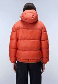 Oranžová péřová bunda s kapucí, která má prošívaný design a elastické manžety. Materiál vypadá lesklý a voděodolný.