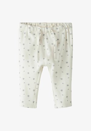Pantalons en jersey de coton couleur crème avec un imprimé floral. Dotés d'une taille élastique et d'un cordon de serrage. Bas des jambes à revers.