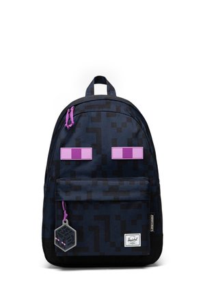 Sac à dos pixelisé noir et gris foncé avec des tirettes de fermeture éclair violettes, deux patchs violets de type pixel et un pendentif cube noir suspendu avec des yeux roses.