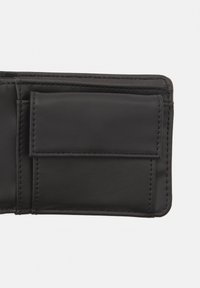 Black leather wallet interior featuring a card slot with clean stitching. Smooth texture and minimalist design.