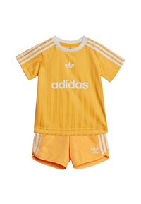 Completo sportivo Adidas giallo composto da una maglietta a maniche corte con righe verticali e logo bianco, abbinata a pantaloncini coordinati con tre righe bianche.