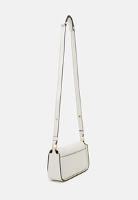 Sac en cuir blanc à bandoulière avec des bords noirs contrastants, de forme rectangulaire plate, bandoulière ajustable et accents en métal doré.