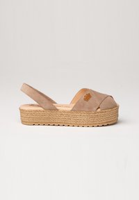Sandalias de plataforma de ante beiges con diseño de tiras cruzadas, plantilla de yute trenzado y suela de goma. Presenta un pequeño logotipo en la tira.