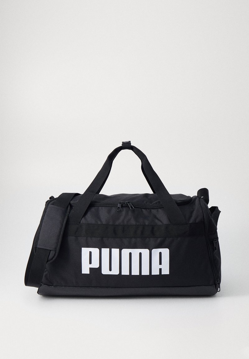 Zwarte sportduffeltas van duurzaam stof, met een groot wit "PUMA" logo, dubbele handvatten en een afneembare schouderriem.