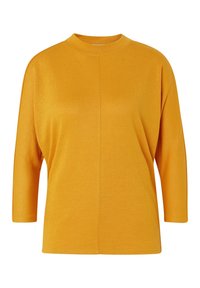 Haut à manches longues jaune moutarde avec un col montant, coupe décontractée et texture côtelée, présentant un détail de couture au centre.