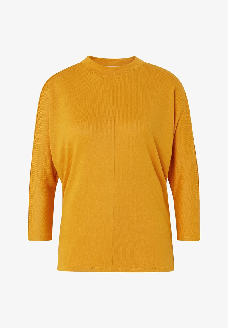 Musztardowa żółta bluzka z długim rękawem, z wysokim dekoltem, luźnym krojem i prążkowaną fakturą, z centralnym szwem.