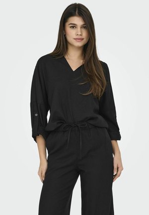 Svart, lätt och lös passande outfit med V-ringning, trekvartslång ärm med knappdetaljer och justerbart midjeband.