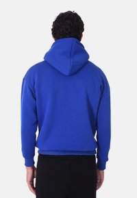 Felpa con cappuccio blu, dalle maniche lunghe e polsini a coste. Tessuto morbido, vestibilità casual, con un grande cappuccio e senza loghi o pattern visibili.