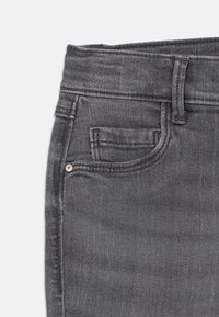 Σκούρες γκρι τζιν παντελόνες με ψηλή μέση, μπροστινές τσέπες και διακριτές ραφές. Λείος υφασμάτινος χαρακτήρας με κλασικό σχέδιο.