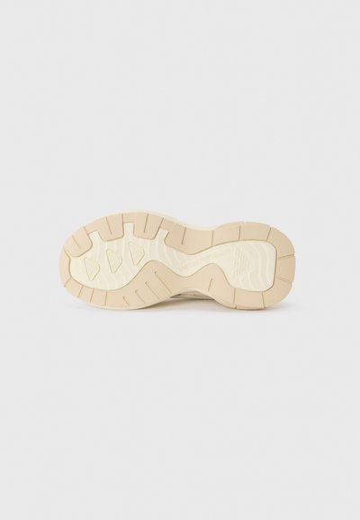 Beige athletic shoe outsole, featuring a textured design, prominent tread pattern, and brand logo. Made of rubber with a smooth finish.
