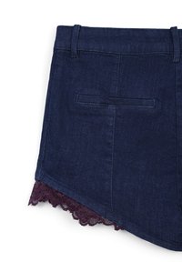 Shorts en denim bleu foncé avec un ourlet en dentelle bordeaux à volants. Comprend une poche arrière et des passants de ceinture. Le matériau semble doux et flexible.