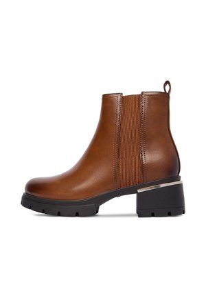 Brūnas ādas potītes zābaki ar elastīgām sānu panelēm, apaļu purngalu un melnu biezpurnu papēdi ar metāla akcentu papēdī.