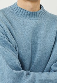Maglione lavorato a maglia azzurro chiaro con scollatura a girocollo a coste, vestibilità ampia e tessuto testurizzato. I dettagli includono maniche larghe e un aspetto morbido e accogliente.