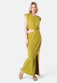 Vestido verde oliva con un top corto y detalle de torsión, que presenta cortes en los laterales y una abertura hasta el muslo, hecho de un material ligero.