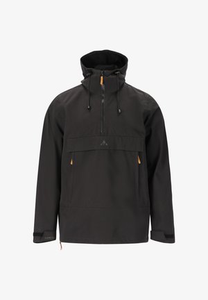 Sort pulloverjakke med en frontlomme, lynlåshals og snoretræk i hætten. Har brune detaljer på lommen og manchetterne. Grå jeans og støvler.