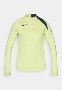 Koszulka sportowa z długim rękawem w jaskrawym żółtym kolorze, z pół-zapięciem na szyi, czarnymi akcentami na ramionach i gładkim, lekkim materiałem. Logo Nike na widoku.
